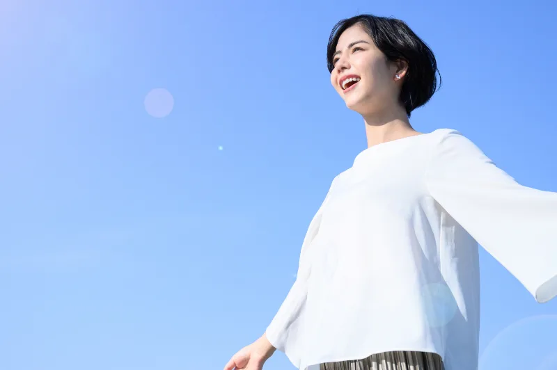 青空でストレスを発散している女性の写真です。