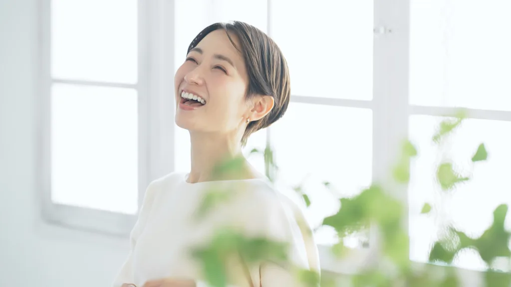 窓辺で笑顔の女性です。